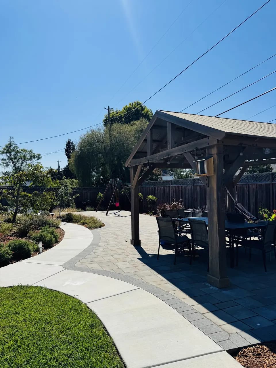Backyard Garden Design with Curved Concrete Walkways and Raised Beds