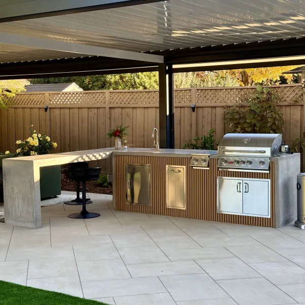 Covered outdoor kitchen with a built-in grill and a seated bar counter